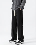 A tall man wearing black cotton straight leg sweatpants, front view
