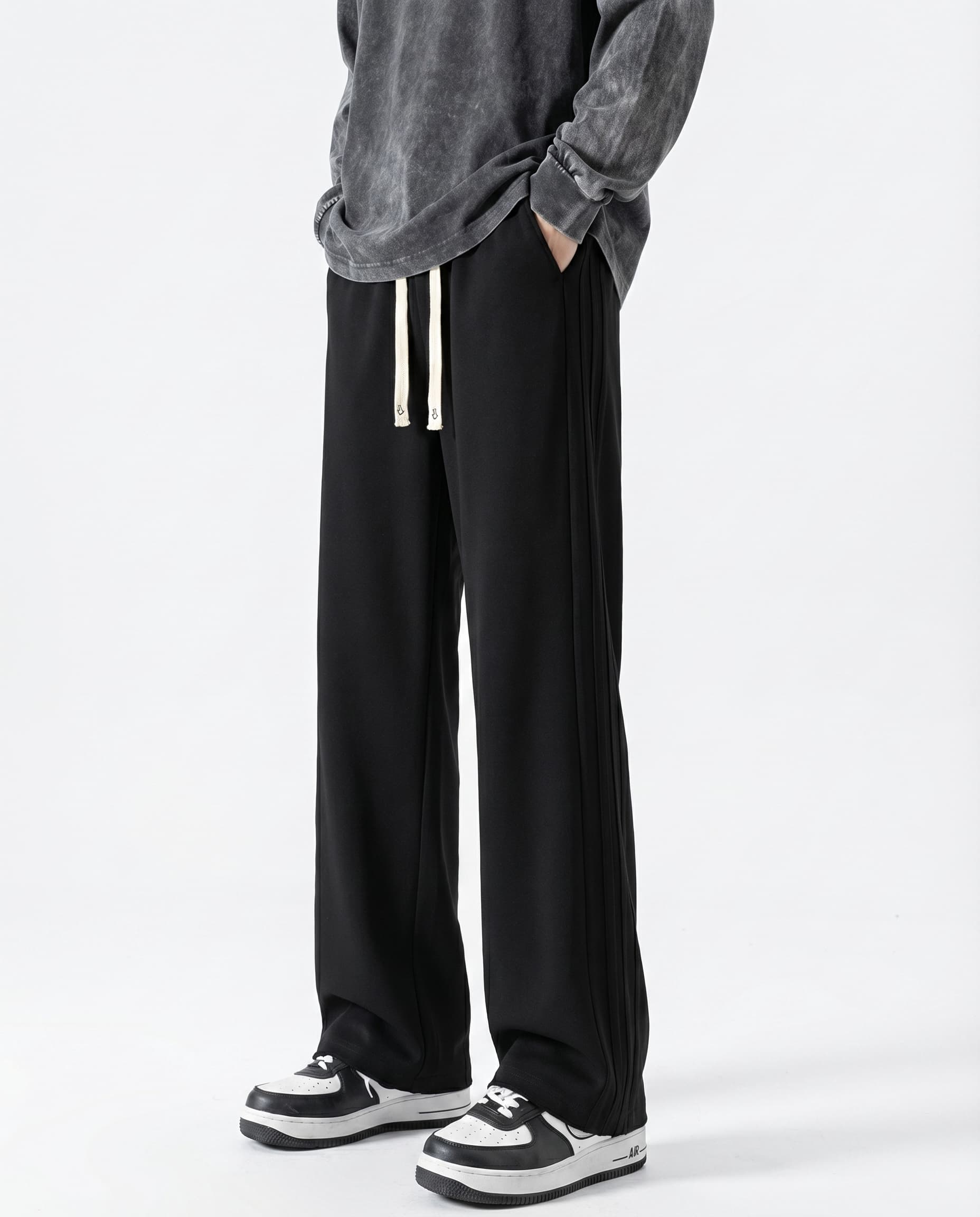 A tall man wearing black cotton straight leg sweatpants, front view