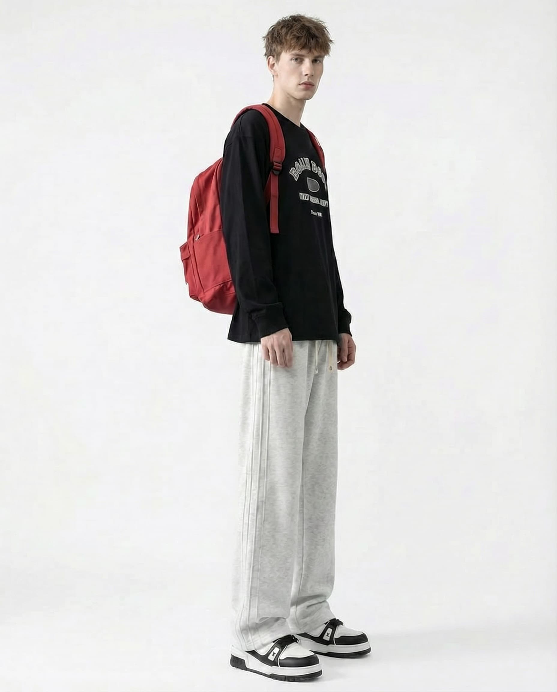 Tall man wearing white sweatpants with red backpack, side view full outfit