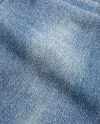 Light blue denim fabric texture detail of relaxed fit jeans