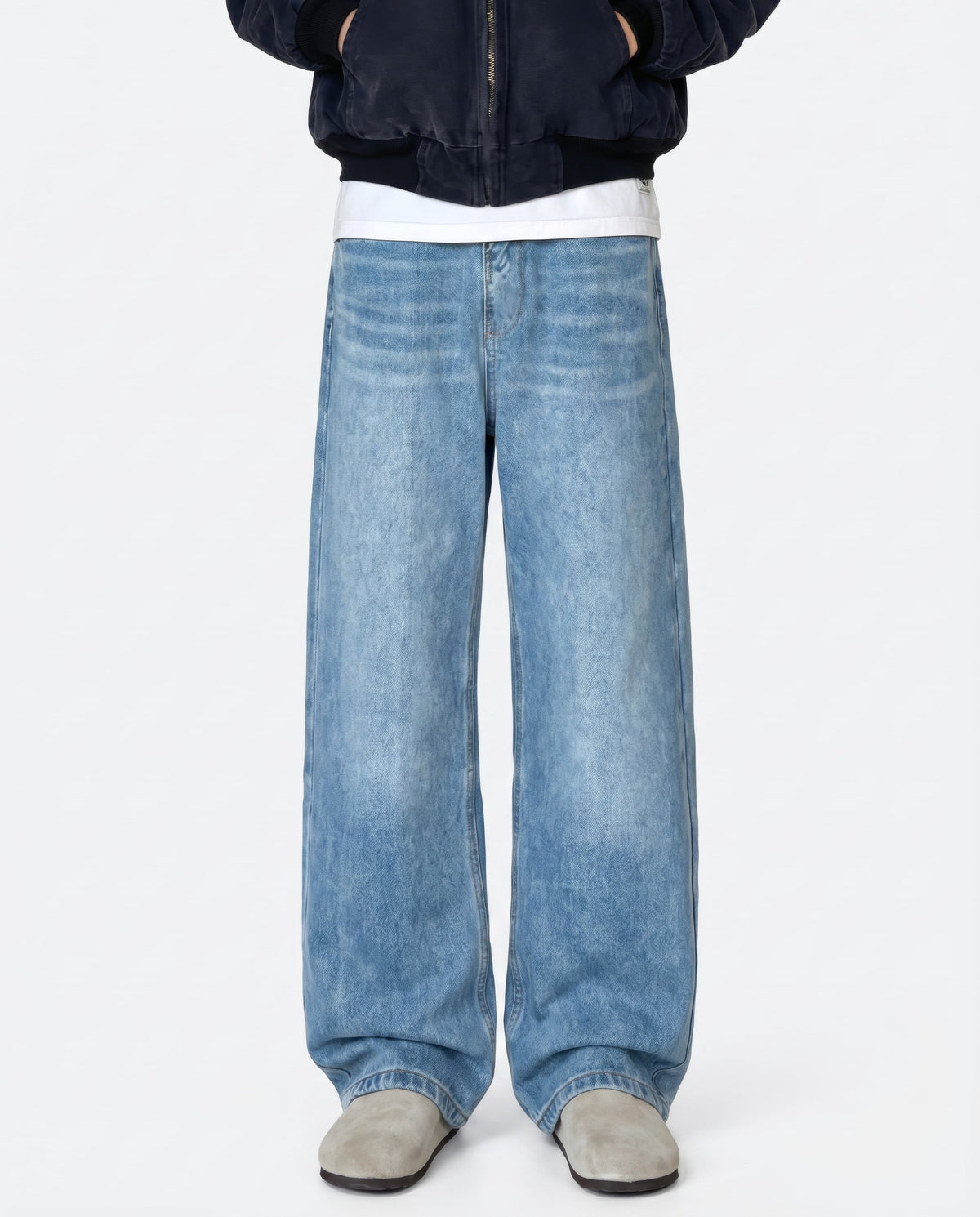 A tall man wearing light blue relaxed fit jeans, standing front-facing
