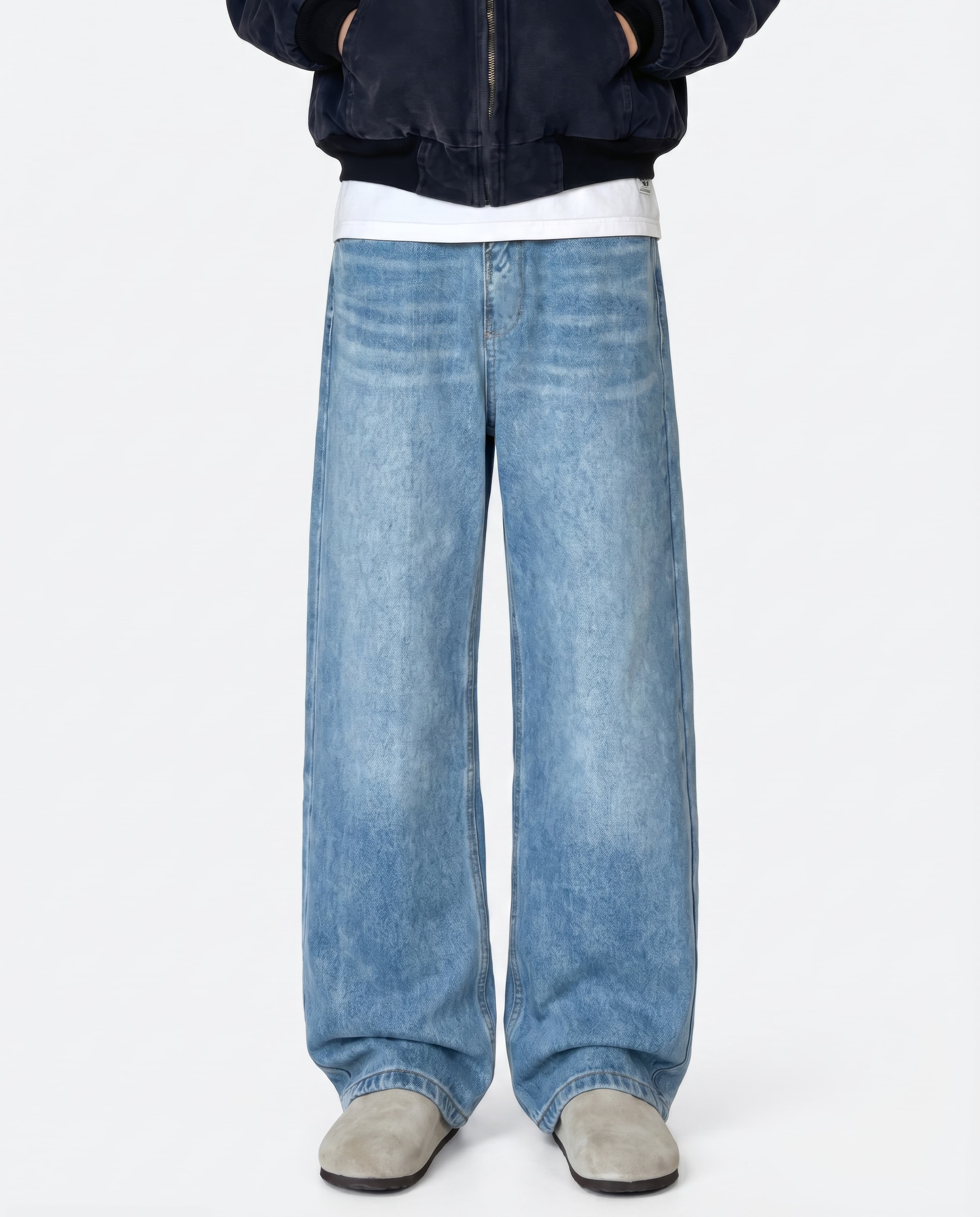 A tall man wearing light blue relaxed fit jeans, standing front-facing