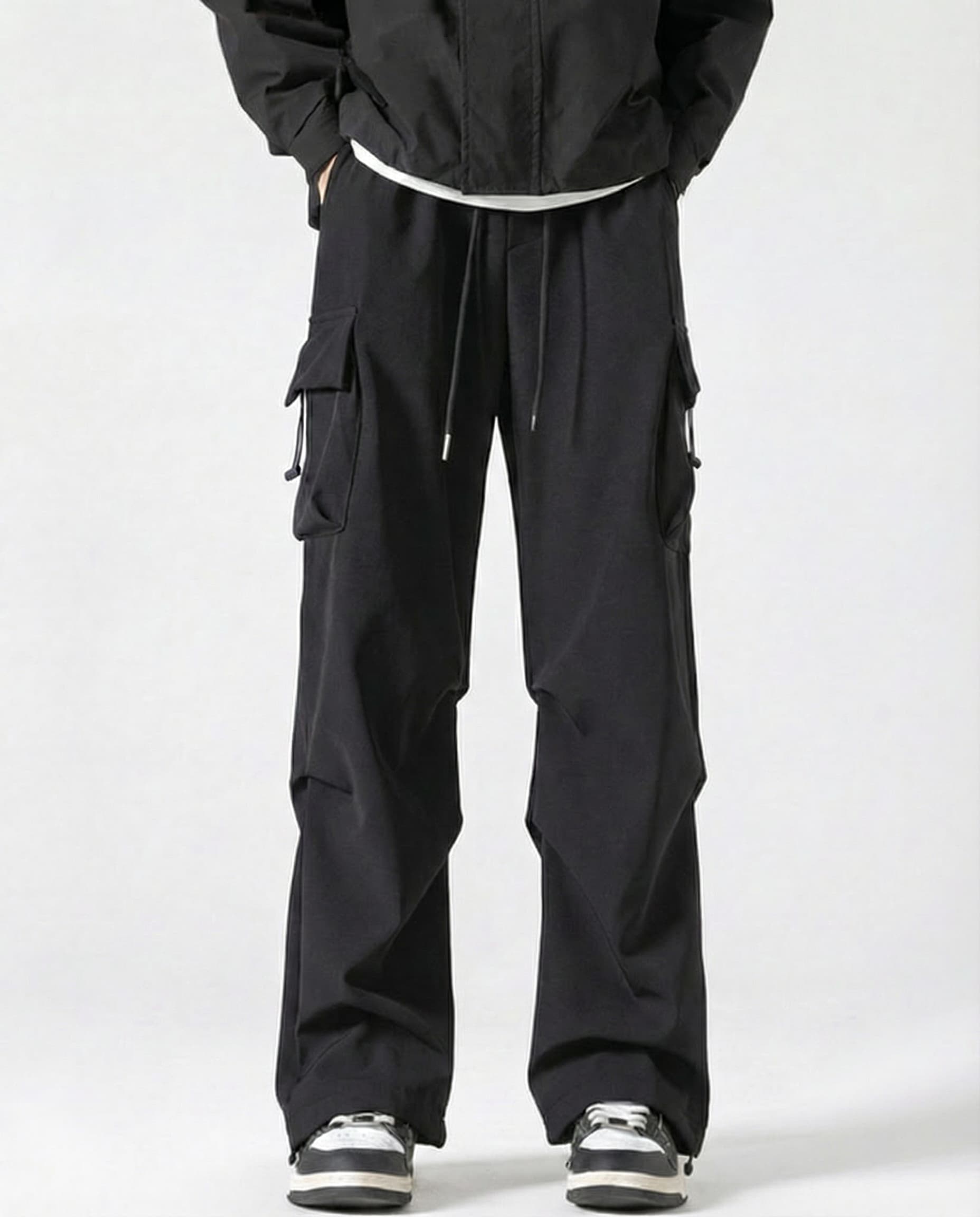 A tall man wearing black straight fit vintage cargo pants, front view full length
