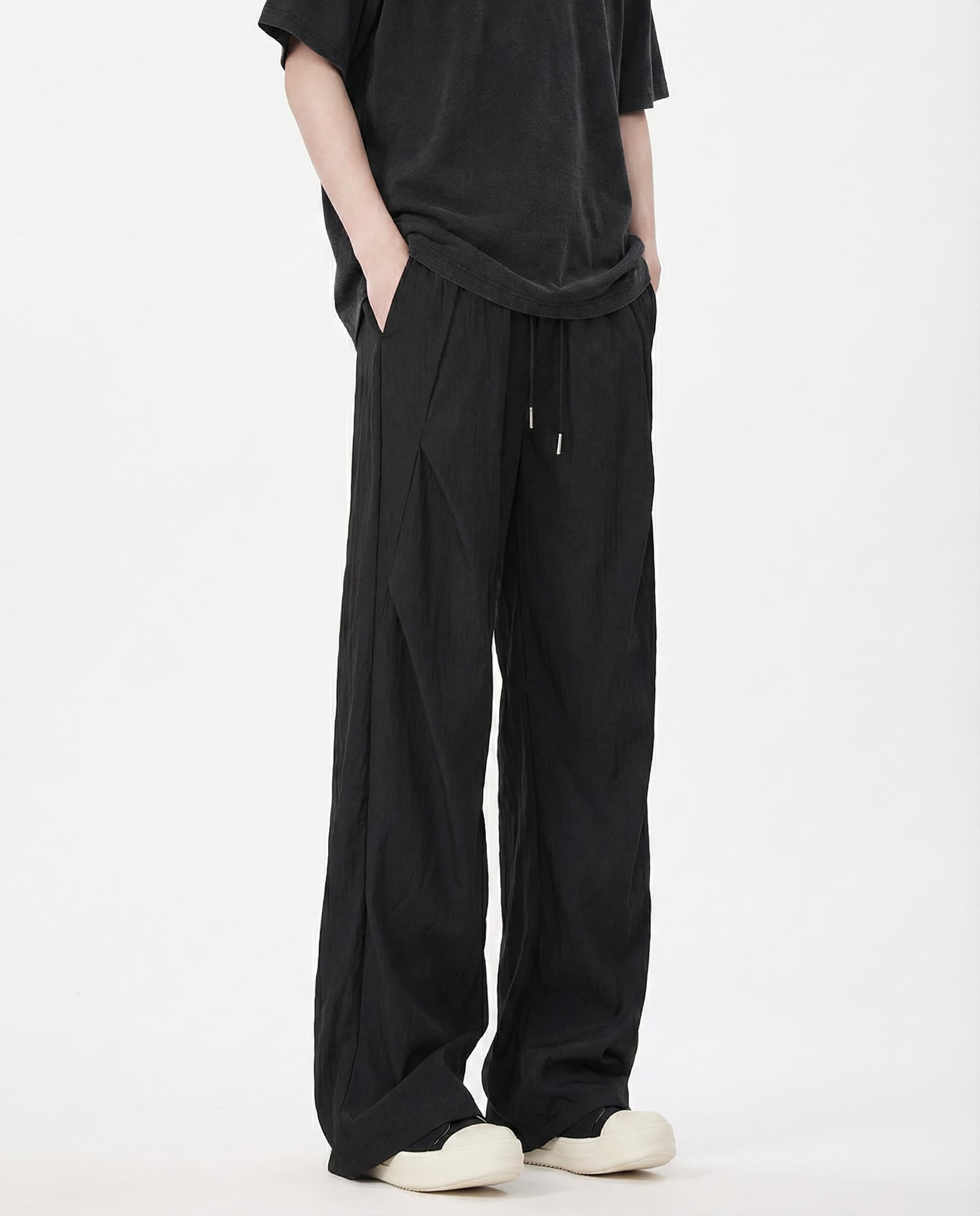 Men's black wide-leg pants for tall men, side profile highlighting fabric drape and leg width
