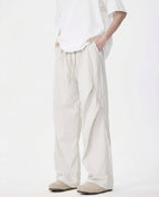 Tall men's white wide-leg trousers, side view showing relaxed fit and full length