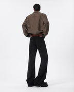 Black mid rise flare jeans for tall men styled with brown jacket, full editorial outfit look