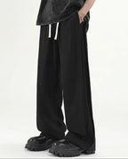 Black pleated wide leg pants for tall men, front view with clean minimal styling and pleat detail