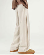 Men's cream wide leg pleated pants for tall men, back view showing waistband design and wide-leg silhouette