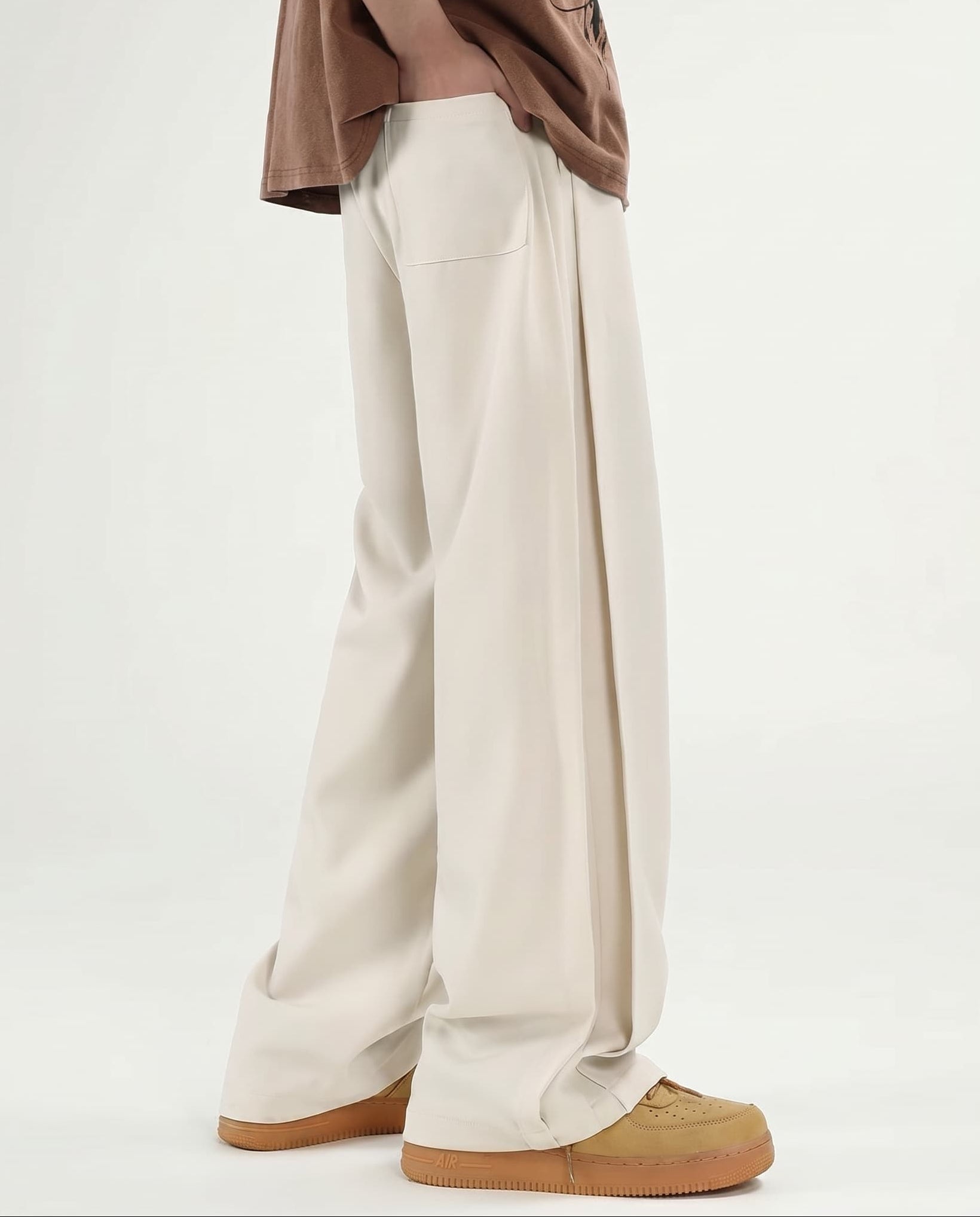 Men's cream wide leg pleated pants for tall men, back view showing waistband design and wide-leg silhouette