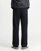 Tall men's black straight leg sweatpants, back profile highlighting straight cut and fabric drape