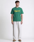 White straight leg sweatpants for tall men styled with green tee, casual color-block outfit look