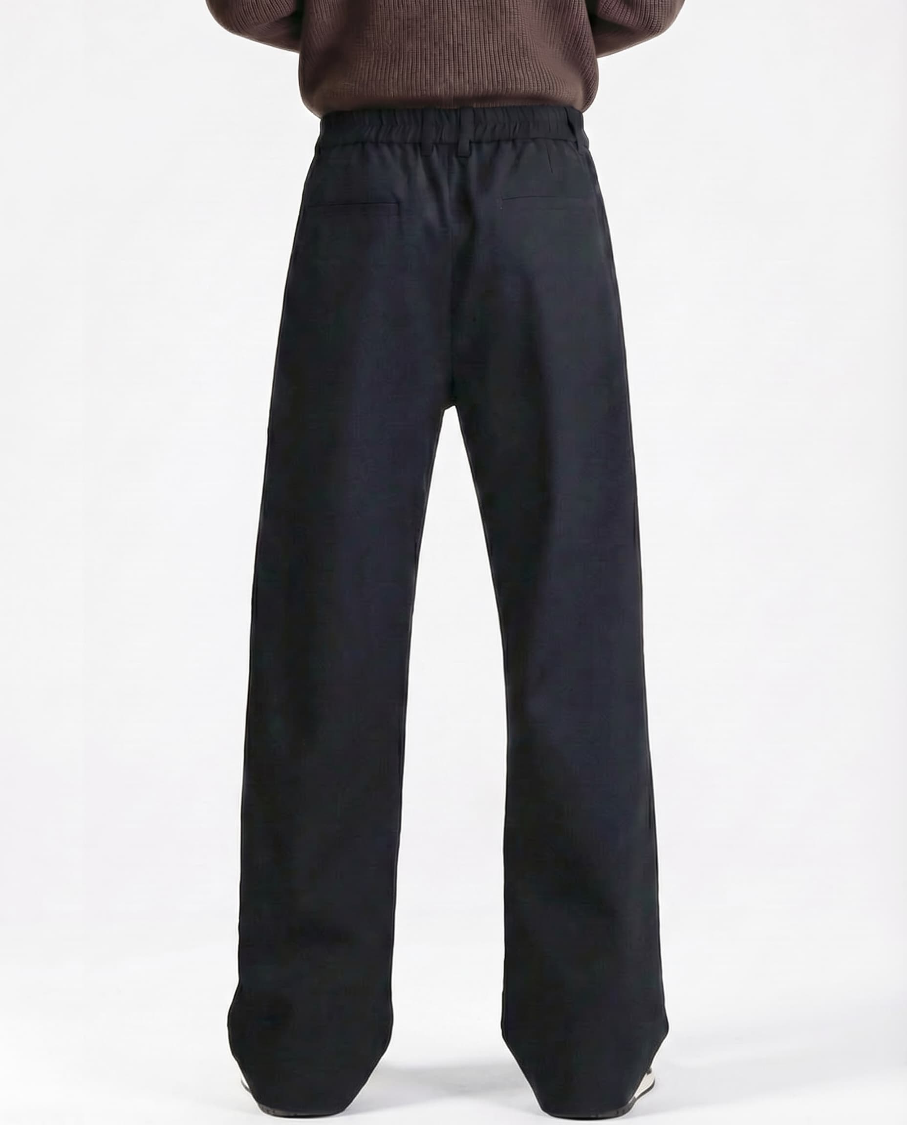Men's black pleated trousers for tall men, back profile showing relaxed fit and fabric drape