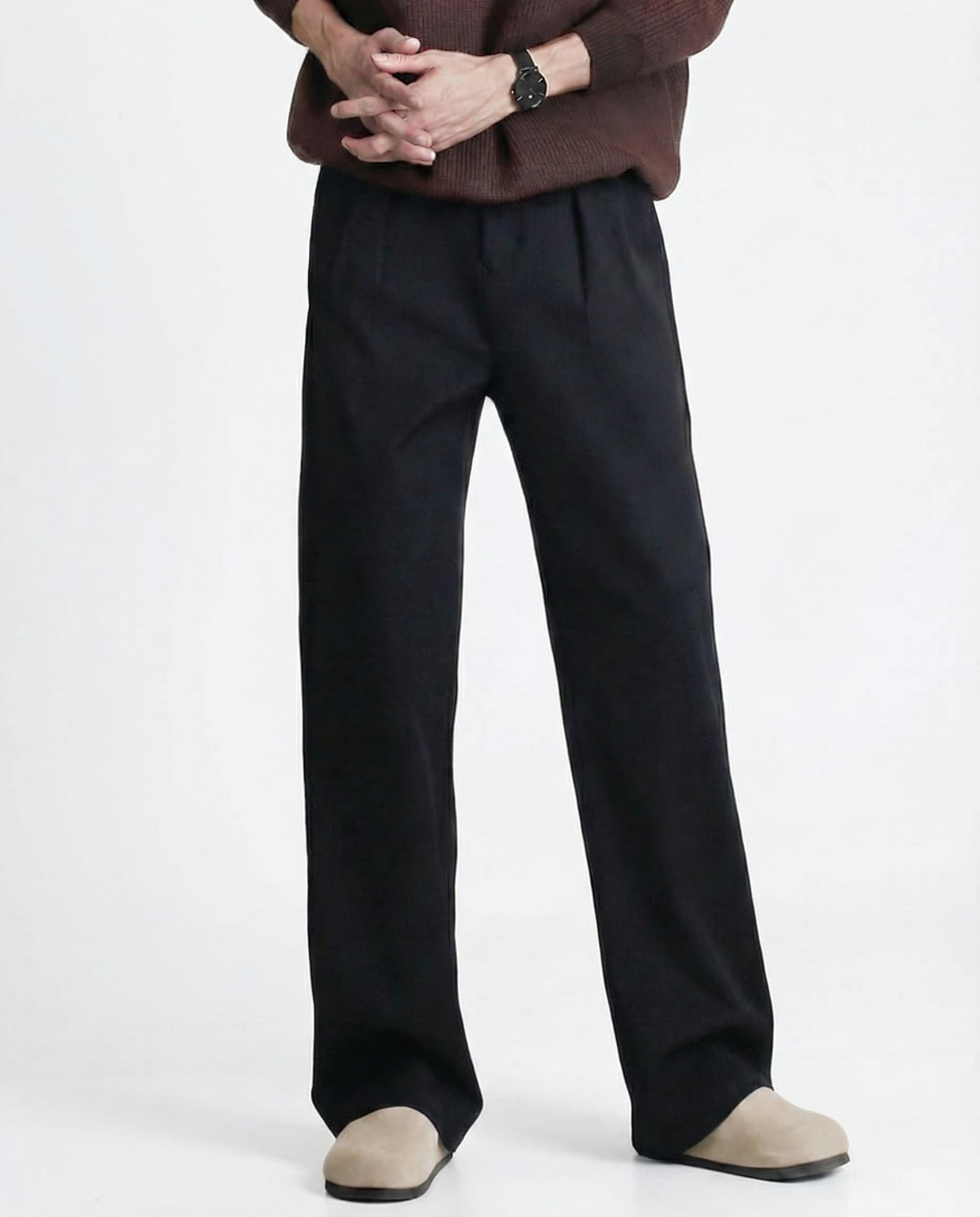 Black relaxed pleated trousers for tall men, full-length side view with casual white sneaker styling