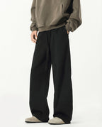 Men's black weekender sweatpants for tall men, side profile showing wide-leg cut and fabric drape