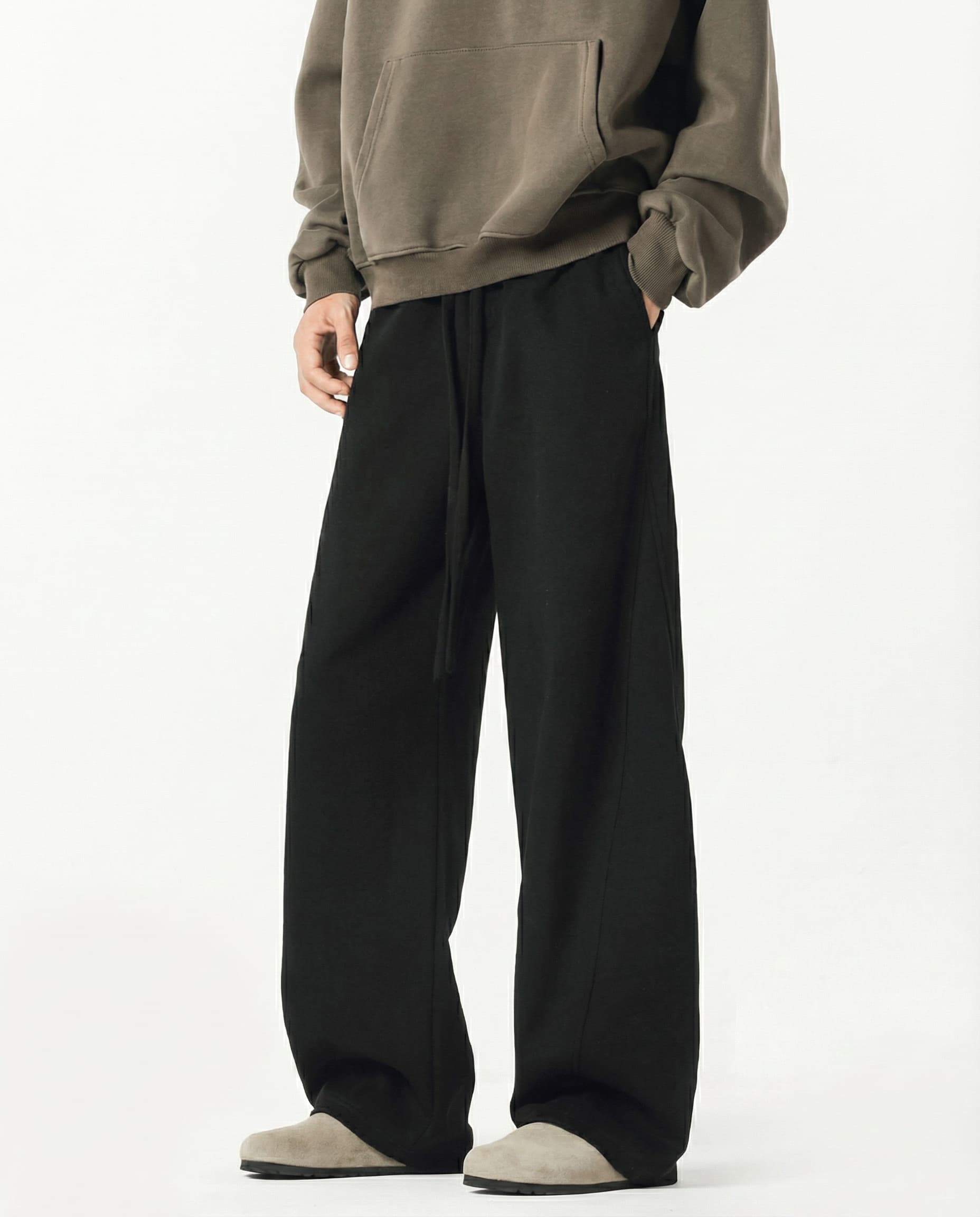 Men's black weekender sweatpants for tall men, side profile showing wide-leg cut and fabric drape