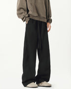 Tall men's black lounge sweatpants, side view showing elastic waistband and wide-leg silhouette