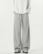 Tall men's gray stretch lounge sweatpants, front view showing wide-leg silhouette and full length