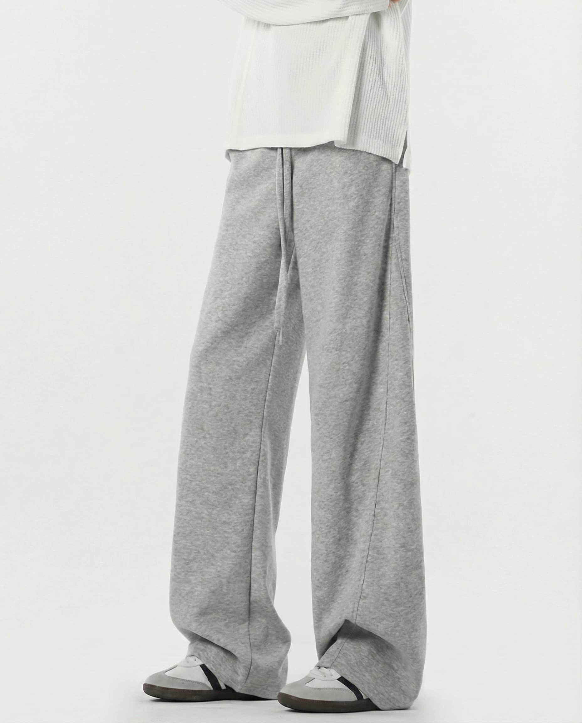 Tall men's gray lounge sweatpants, side profile highlighting stretch fabric drape and leg width